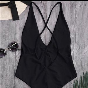 One piece black swim suit, traps along back.